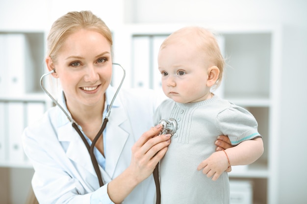 Médico e paciente no hospital. Menina está sendo examinada pelo médico com estetoscópio. Conceito de medicina.