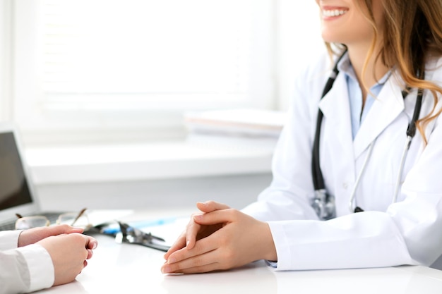 Foto médico e paciente sentados à mesa. conceito de medicina e cuidados de saúde