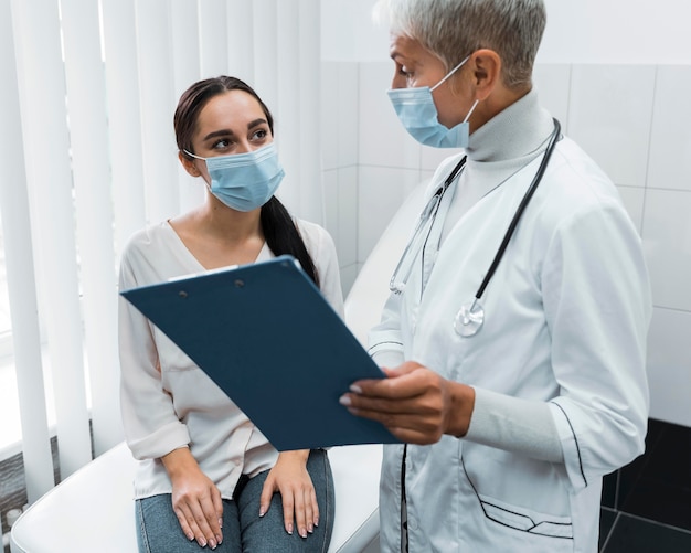 Foto médico e paciente usando máscaras faciais