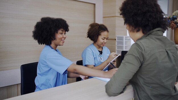 Médico e recepção conversando com um paciente no hospital. Saúde e bem estar.