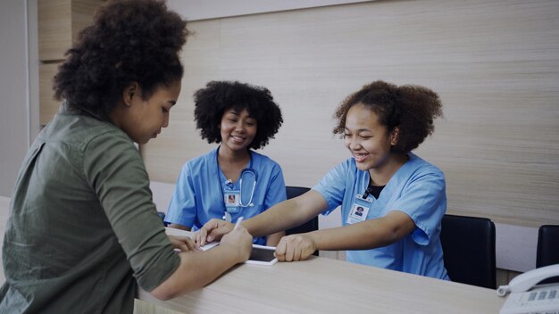 Médico e recepção conversando com um paciente no hospital. Saúde e bem estar.