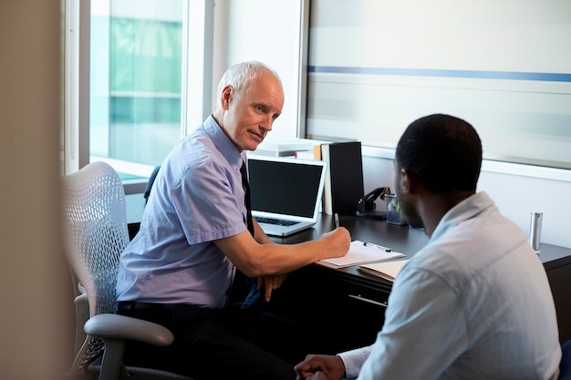 Médico em consulta com paciente do sexo masculino no escritório