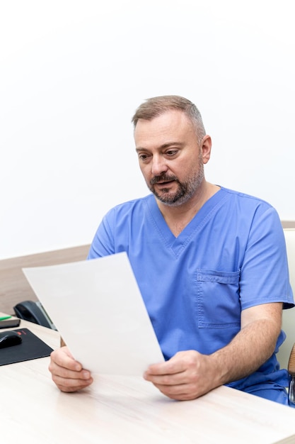 Médico em consultório médico. Trabalhador médico lendo a conclusão médica. Monitore com resultados em segundo plano.