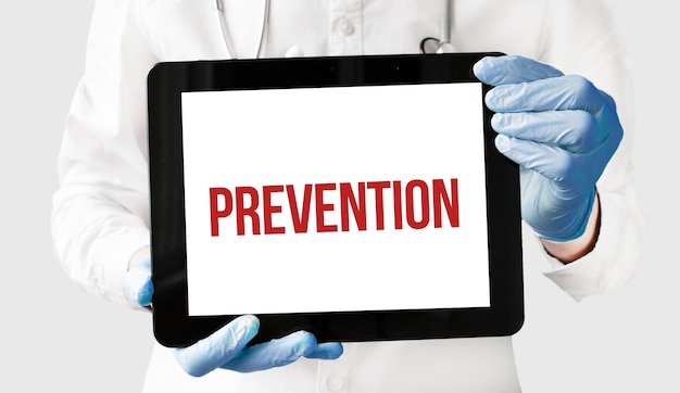 Médico em segura um tablet com o texto PREVENÇÃO