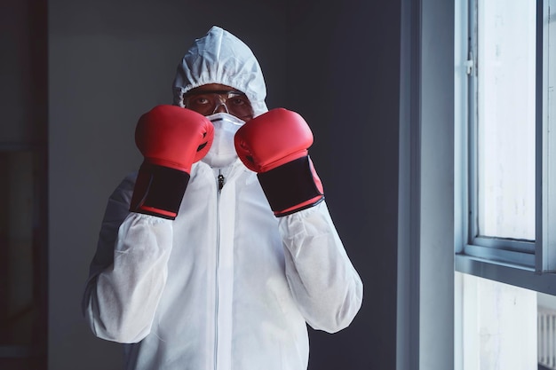 Médico em traje de proteção com luvas de boxe