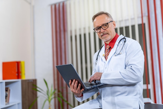 Médico em uniforme médico trabalhando com tablet. Médico feliz masculino com estetoscópio.