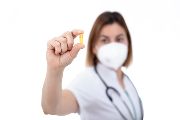 Médico, enfermeiro e farmacêutico olhando para uma pílula amarela.
