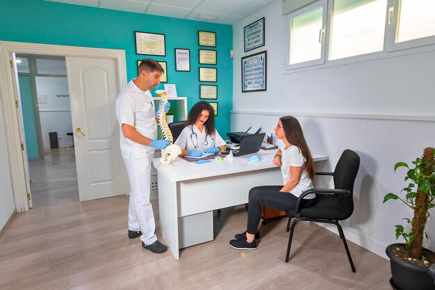 Médico y enfermera atienden al paciente en consulta.