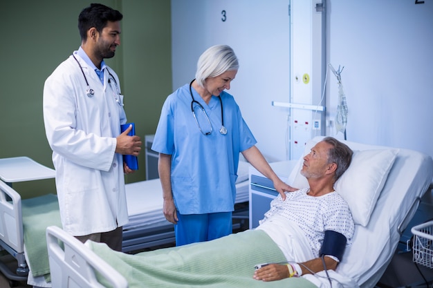 Médico y enfermera examinando a un paciente