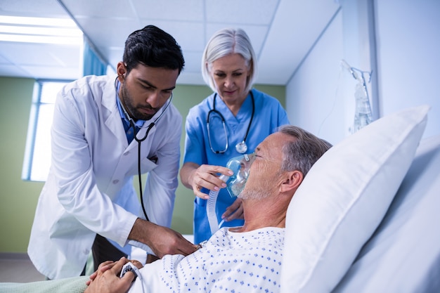 Médico y enfermera examinando a un paciente