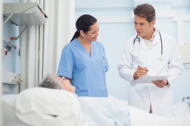 Foto médico y enfermera hablando con un paciente