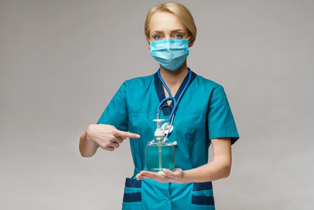 Médico enfermera con máscara protectora con spray desinfectante o gel o jabón líquido