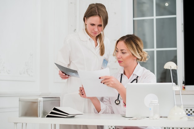 Médico y enfermera mirando documentos en consultorio médico