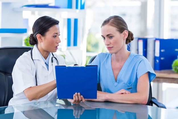 Médico y enfermera mirando el portapapeles