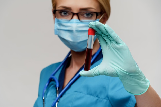 Médico, enfermera, mujer, llevando, máscara protectora, y, guantes, tenencia, estante, con, virus, análisis de sangre
