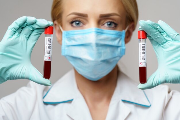 Médico, enfermera, mujer, llevando, máscara protectora, y, guantes, -, tenencia, virus, sangre, prueba