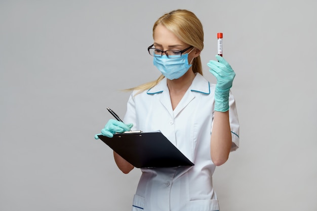 Médico, enfermera, mujer, llevando, máscara protectora, y guantes