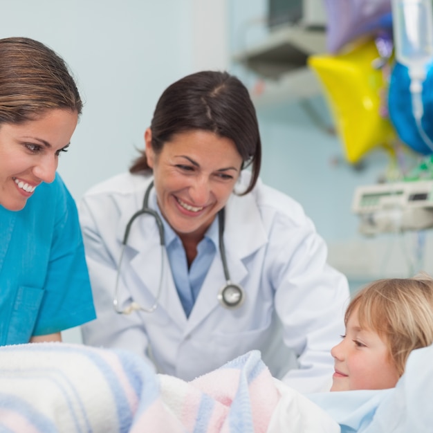 Foto médico y enfermera sonriendo a un niño