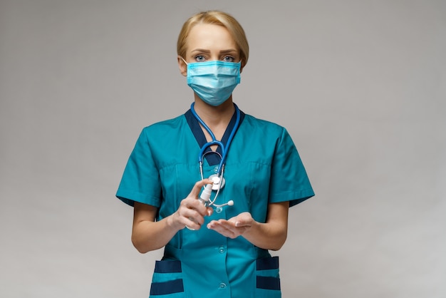 Médico enfermera usando una máscara protectora sosteniendo una botella de spray o gel desinfectante