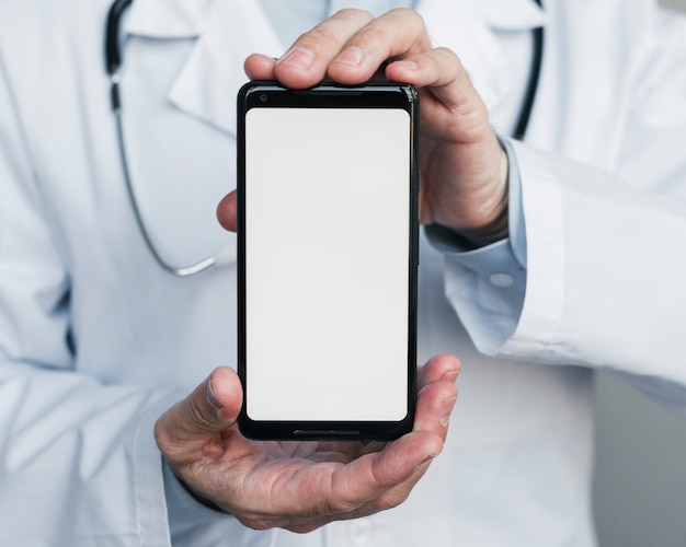 Médico enseñando un teléfono móvil