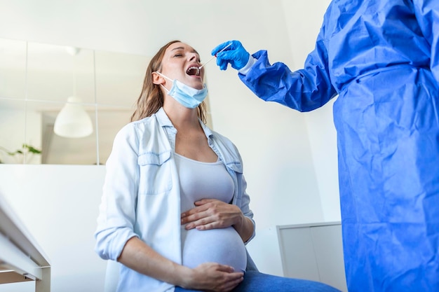 Médico con equipo de protección personal que realiza una prueba de PCR COVID-19 de coronavirus, proceso de recolección de muestras de muestras de hisopo de NP nasal y OP oral de mujer embarazada, procedimiento de ADN viral rt-PCR