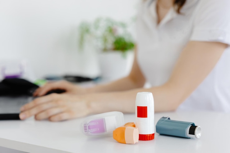 Foto el médico escribe en la computadora portátil una receta médica para un inhalador de asma a un paciente asmático durante la consulta médica y el examen en la clínica