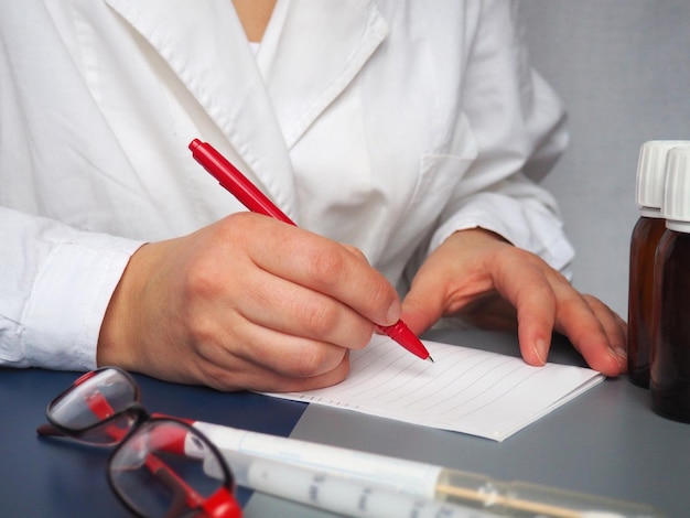 El médico escribe la receta en papel Manos de un médico o una enfermera