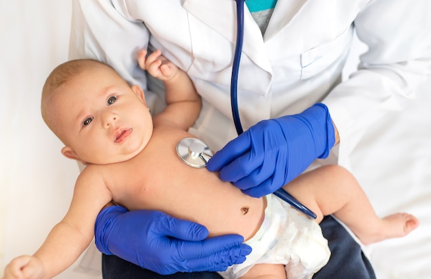 Foto médico escuta o bebê com um estetoscópio