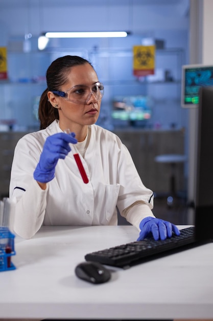 Médico especialista escribiendo experiencia en bioquímica en equipo que trabaja en el experimento de microbiología en el laboratorio del hospital farmacéutico. Investigador biólogo desarrollando vacuna contra coronavirus