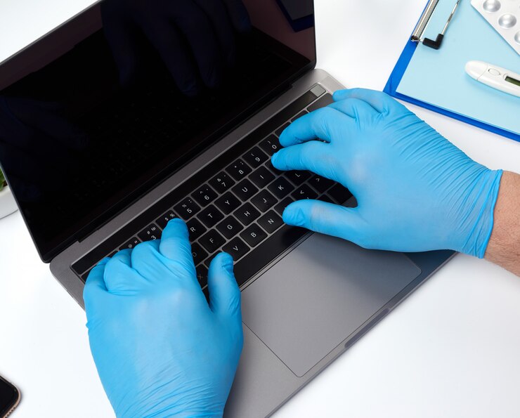 Foto médico especialista en guantes médicos de látex azul trabajando en una computadora portátil, concepto de mantenimiento remoto
