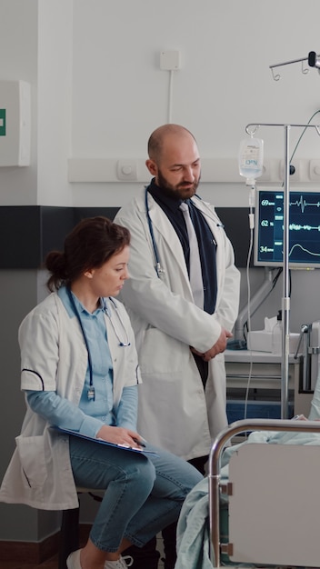 Médico especialista en monitoreo de pacientes enfermos explicando el tratamiento de la enfermedad