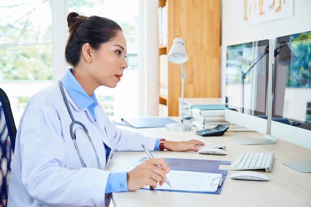 Médico especialista trabajando con computadoras