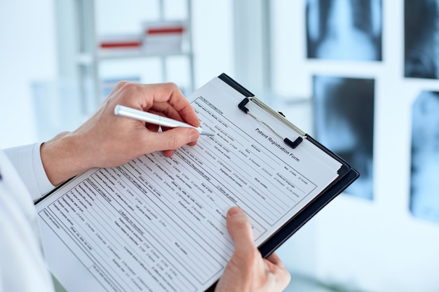 El médico está completando el formulario de registro de pacientes.