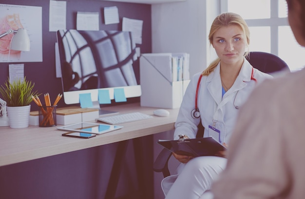 Un médico está hablando y examinando a un paciente.