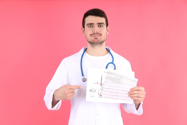 Médico - estagiário com eletrocardiograma em fundo rosa