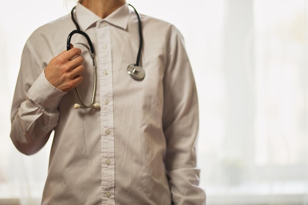 médico con un estetoscopio en el fondo del hospital Un médico en una bata blanca con un estetoscopio