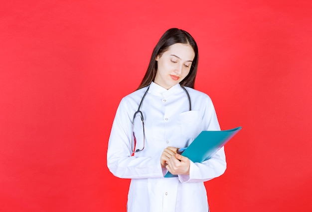 Médico con un estetoscopio sosteniendo la historia del paciente.