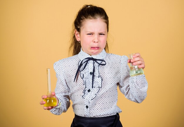 Médico estresado y cansado. pequeña niña estresada con matraz de prueba. lección de bilogía de estudio infantil. De vuelta a la escuela. investigación científica en laboratorio. Niña de la escuela pequeña. educación y conocimiento. chica doctora cansada.