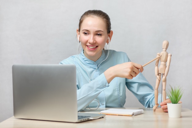 Médico estudante está fazendo exames on-line mostrando respostas em um manequim.