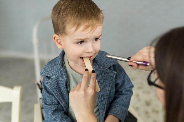 Médico examina la garganta del niño Niño en la oficina del pediatra