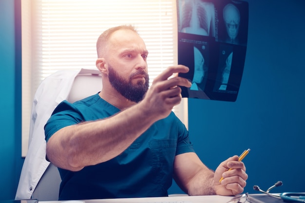 Foto médico examina o raio x e ressonância magnética no escritório