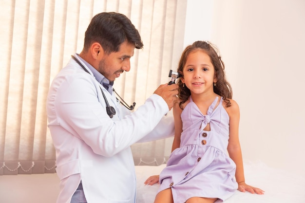 El médico examina el oído con otoscopio en una sala de pediatría. Equipo medico