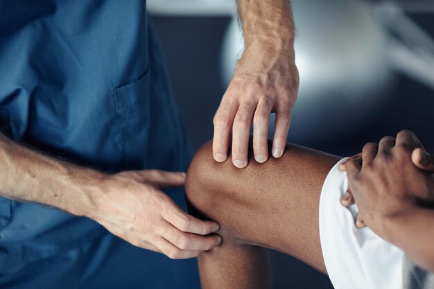 Médico examinando dor na perna do paciente