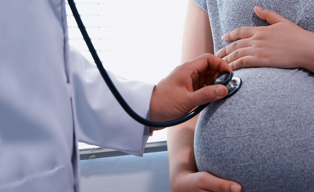 Médico examinando a una mujer embarazada