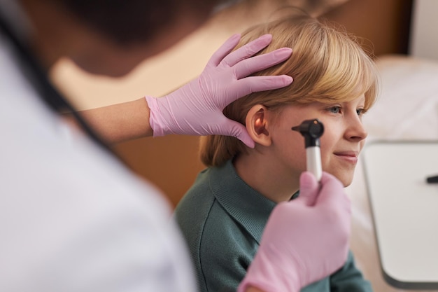 Foto médico examinando los oídos y el oído de los niños en la clínica