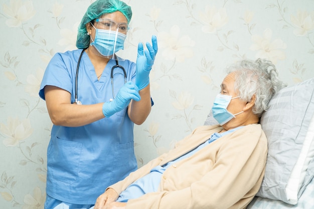 Médico examinando paciente idosa asiática para proteção do Coronavírus Covid-19.
