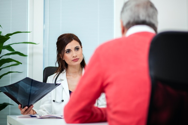 Médico examinando una radiografía con su paciente.