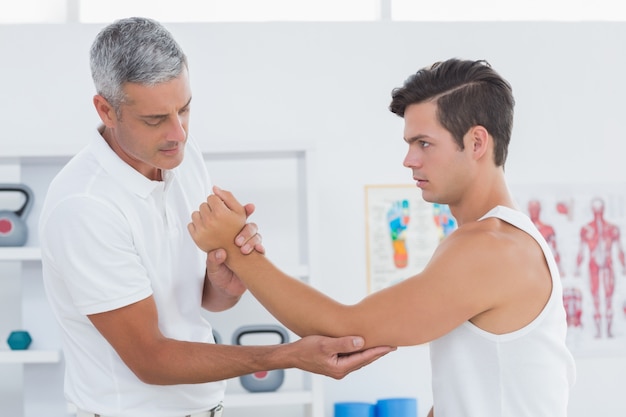 Médico examinando seu braço paciente