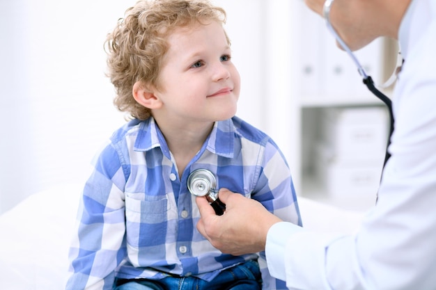 Médico examinando um paciente infantil por estetoscópio