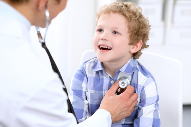 Médico examinando um paciente infantil por estetoscópio